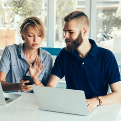 A couple is seated in front of their laptop discussing steps to cut your carbon footprint by 50%