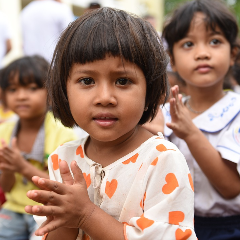 A young girl in a daycare clapping hands