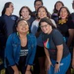 Eight young women who work for Native Now Youth Campaign smiling at the camera